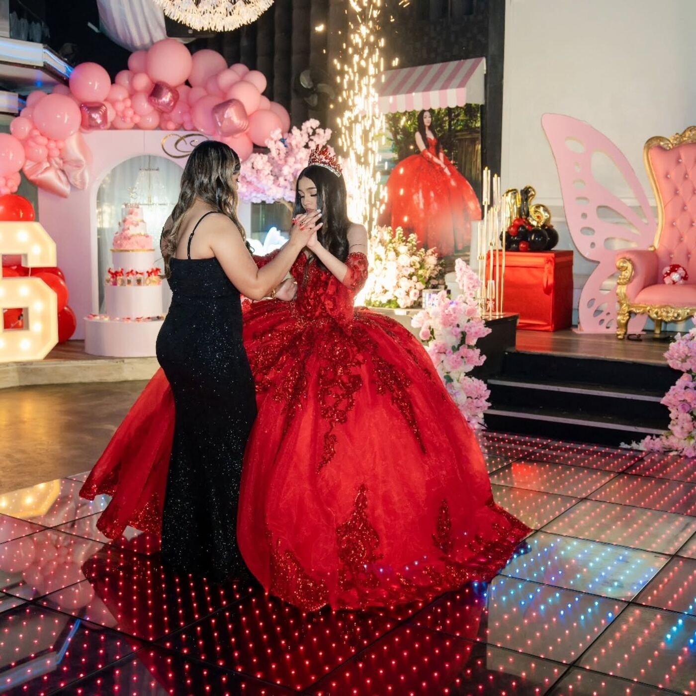 Quinceañera bailando junto a una columna de chispa fría
