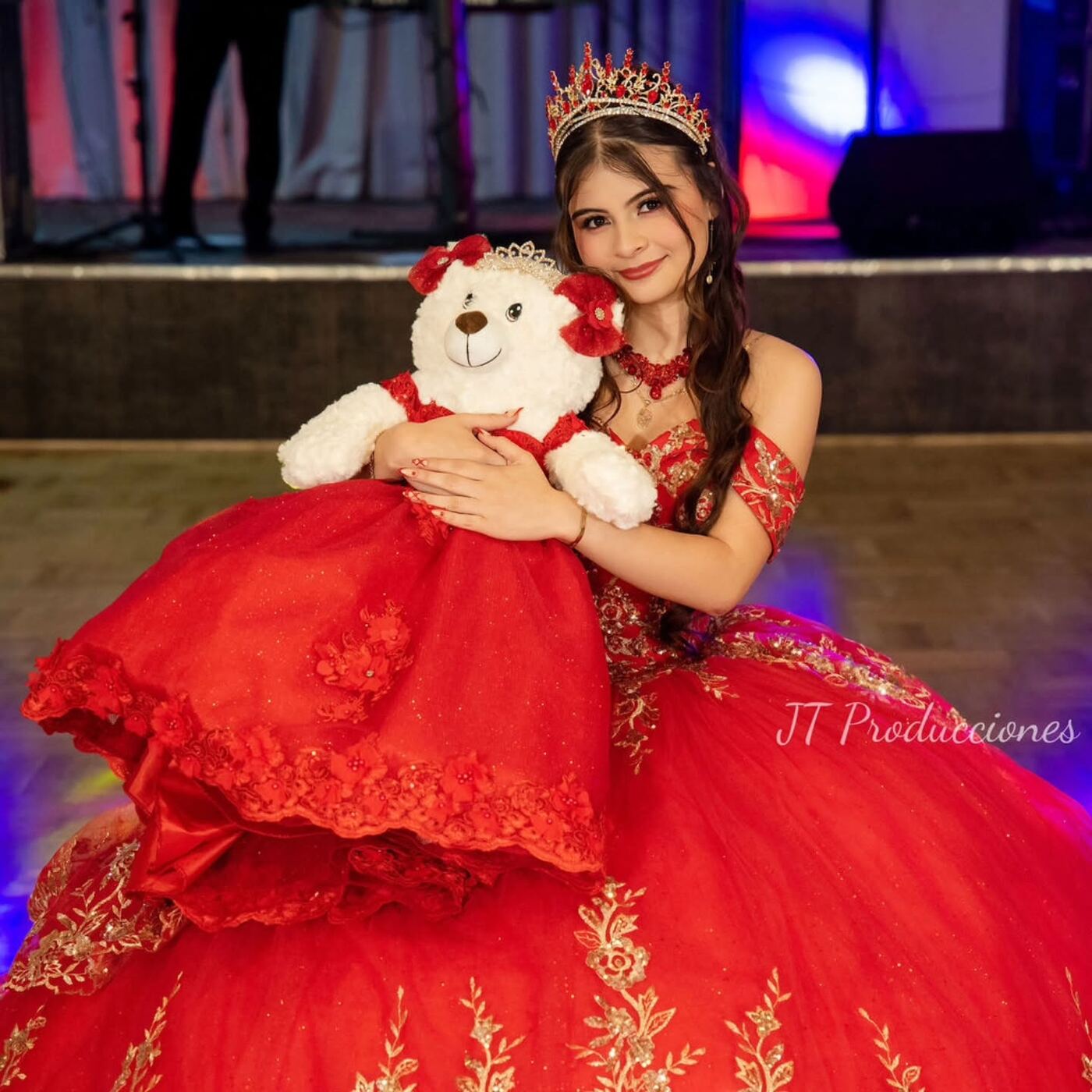 Quinceañera con vestido rojo y su oso de peluche