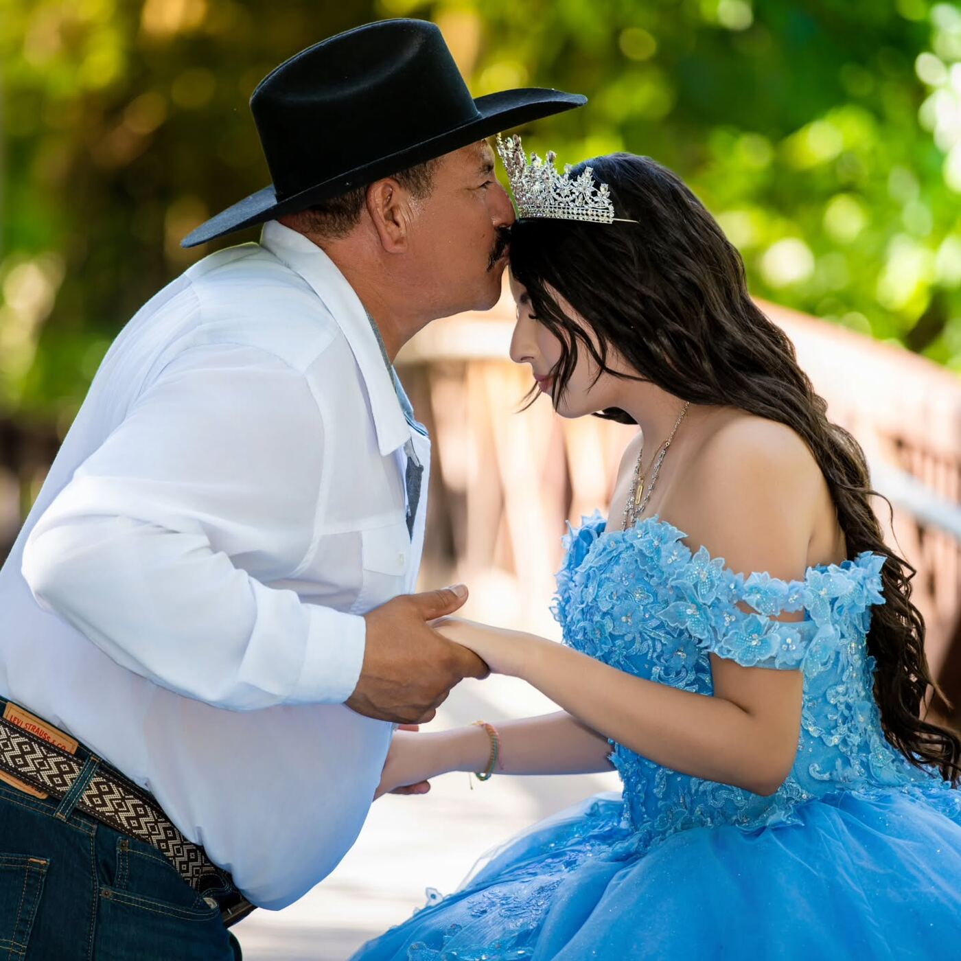 Padre besando la frente de su hija quinceañera