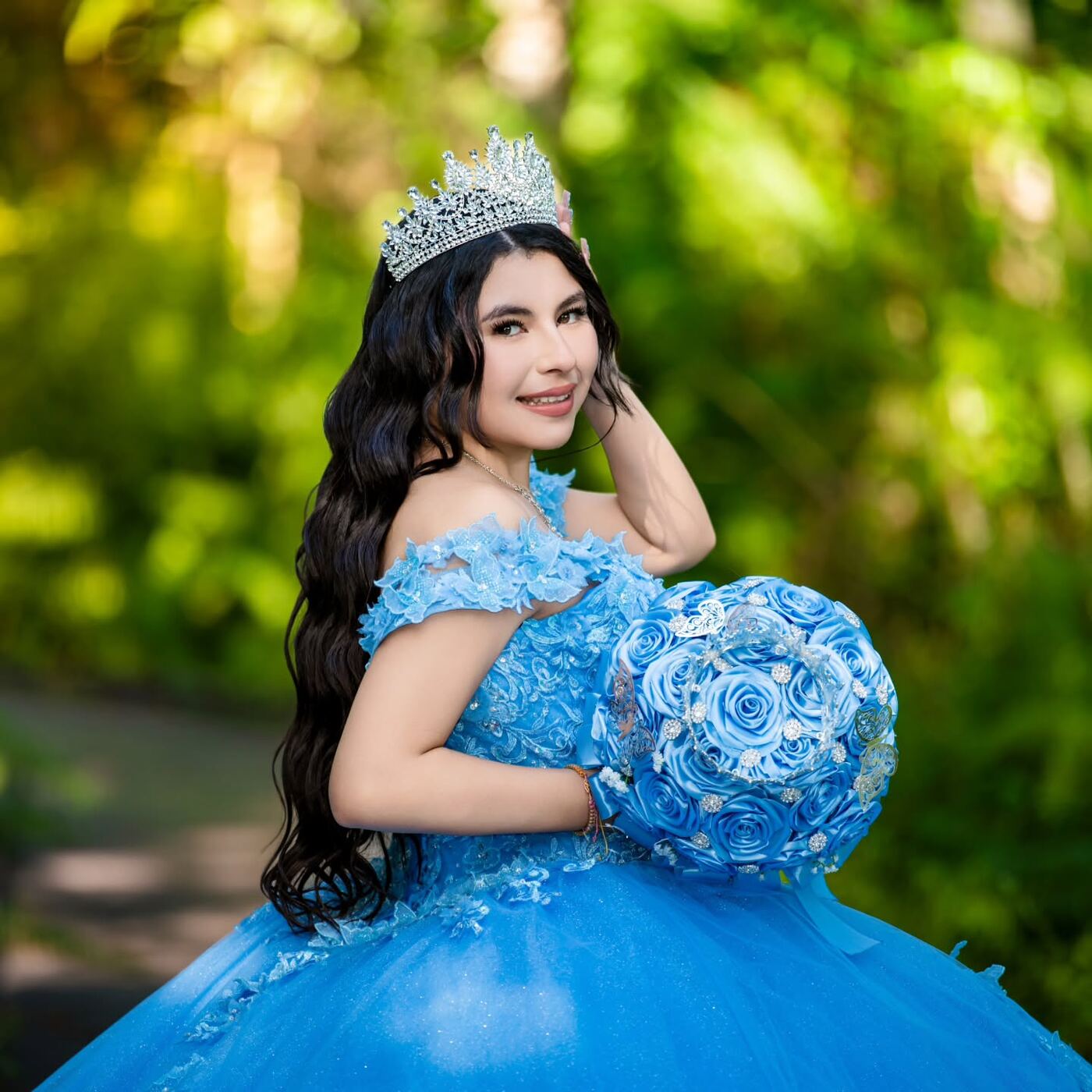 Quinceañera con vestido azul y ramo