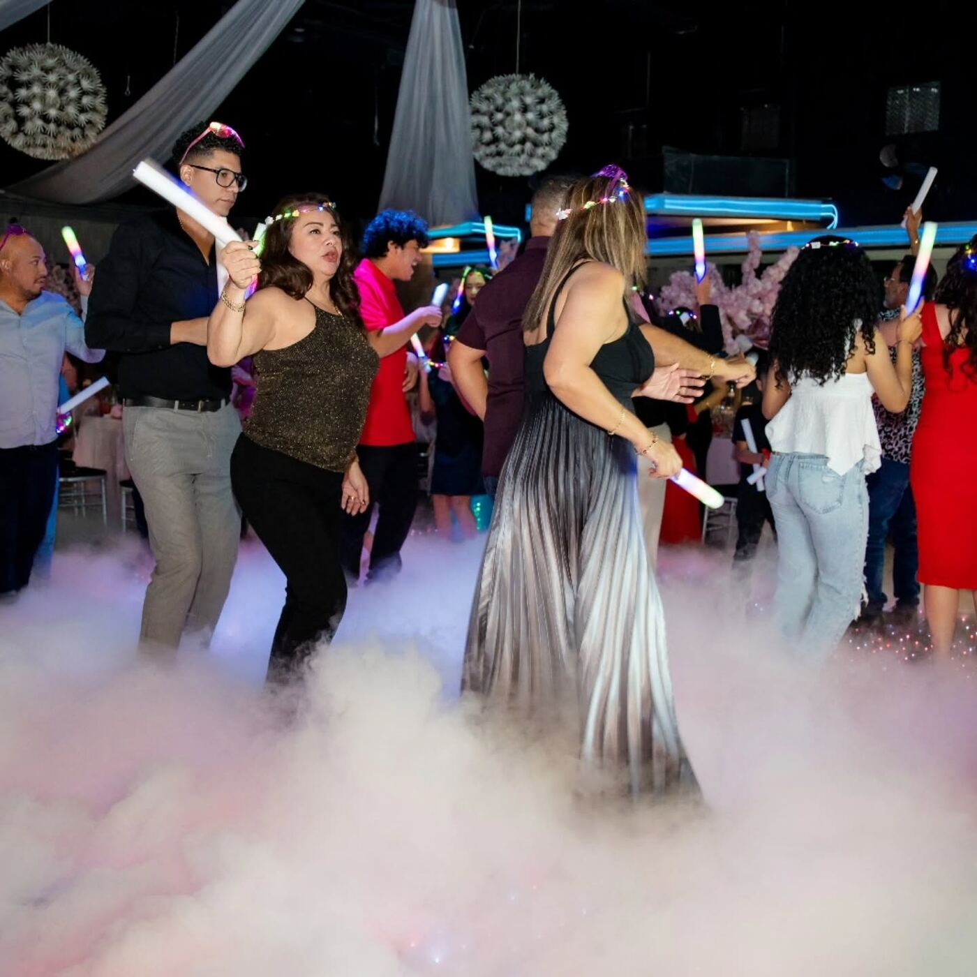 Invitados bailando sobre niebla baja en la pista